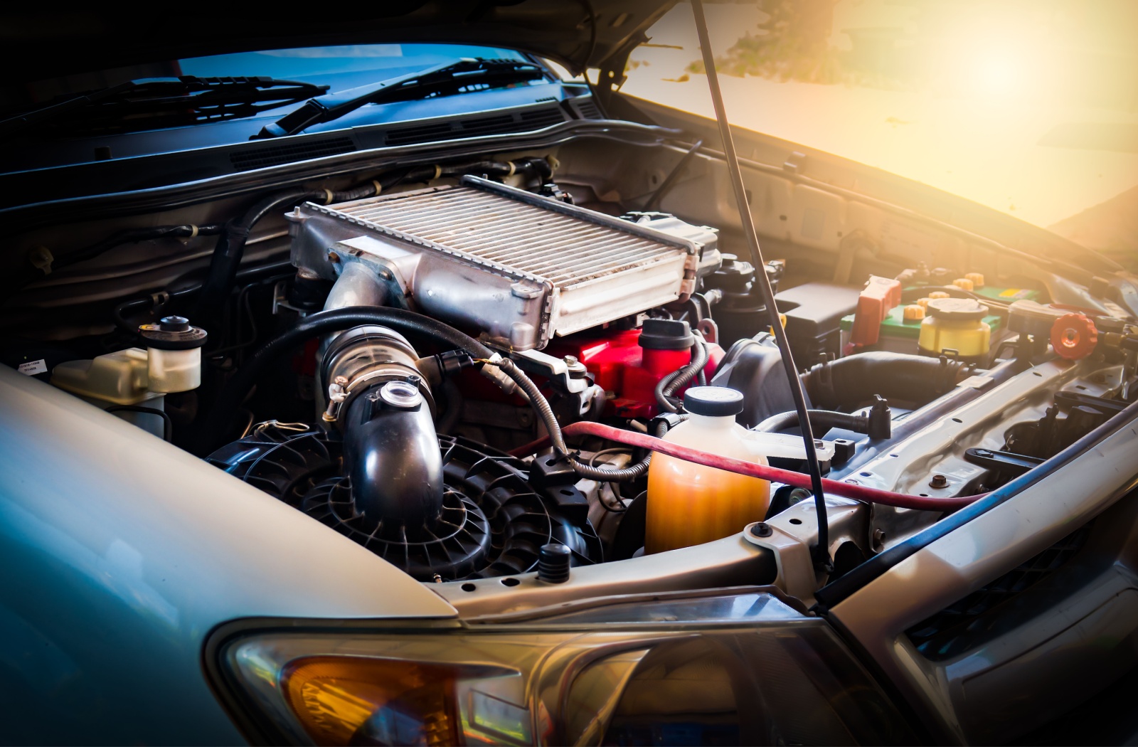 Car engine with an exposed radiator and connected components under the hood.