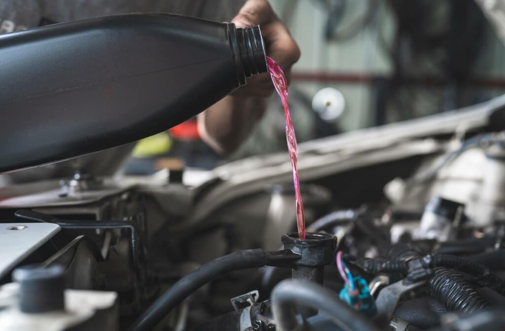 A close-up image of someone adding coolant to a radiator to bring it to the optimal level.