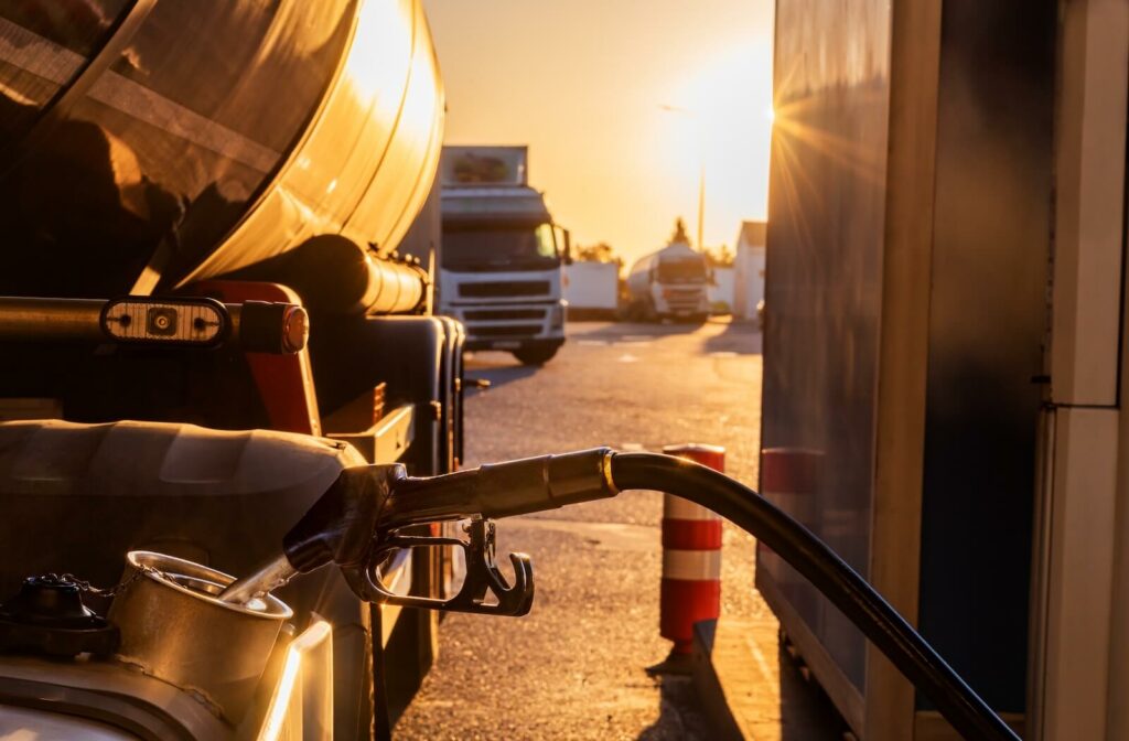 A semi-truck filling up gas at a gas station.