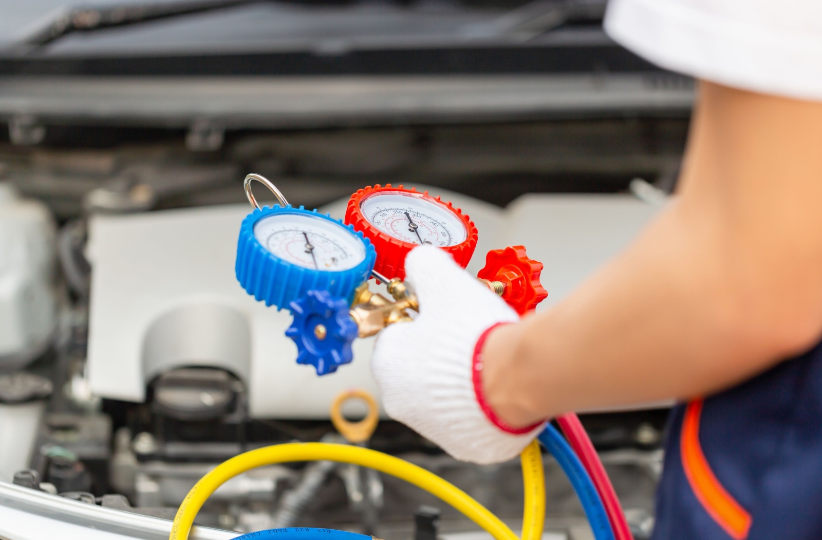 A close-up image of a technician testing a car's AC system to ensure there are no leaks causing a bad smell.
