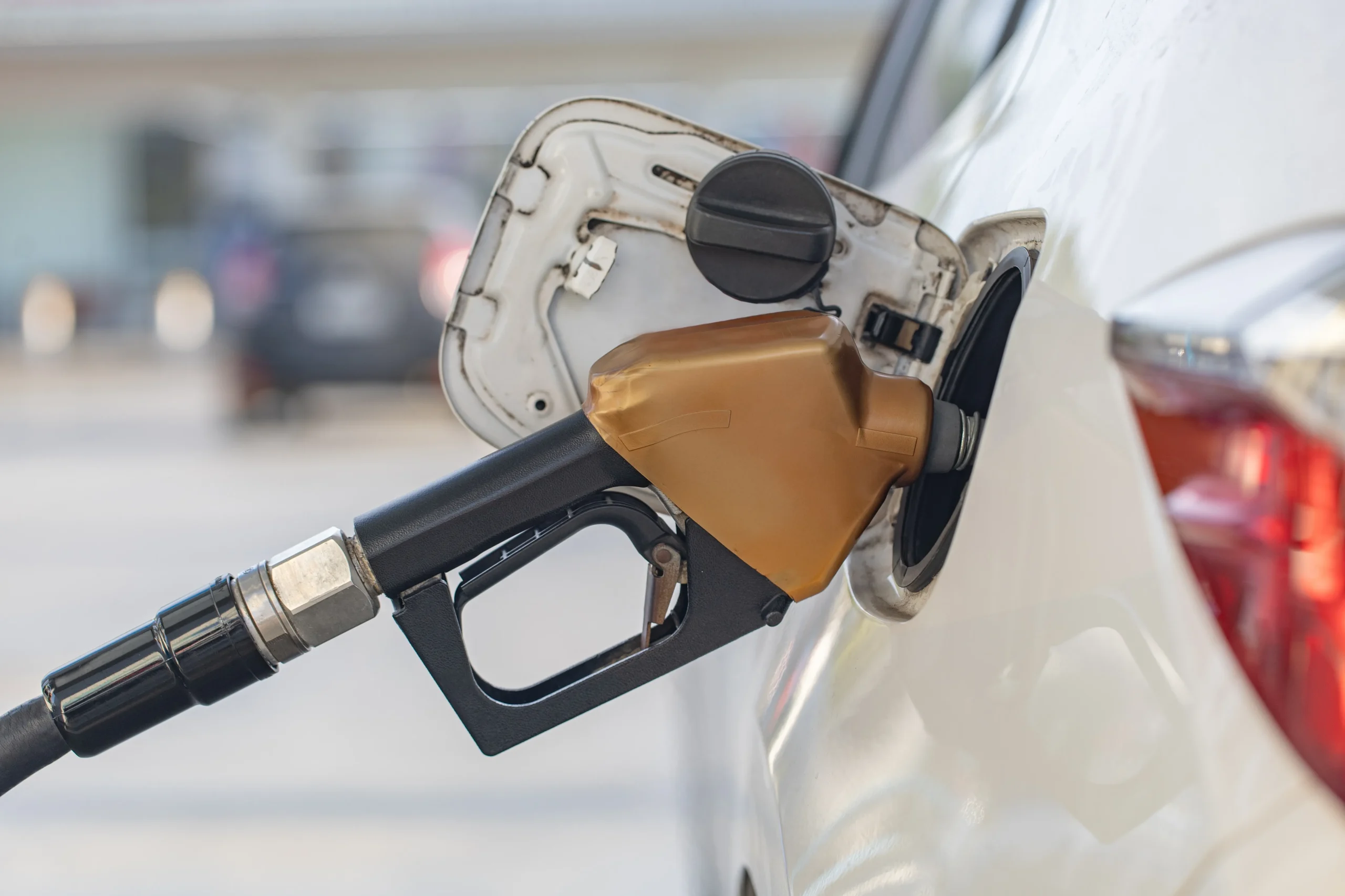 Fuel gas tanks are being refueled with a nozzle at a gas station