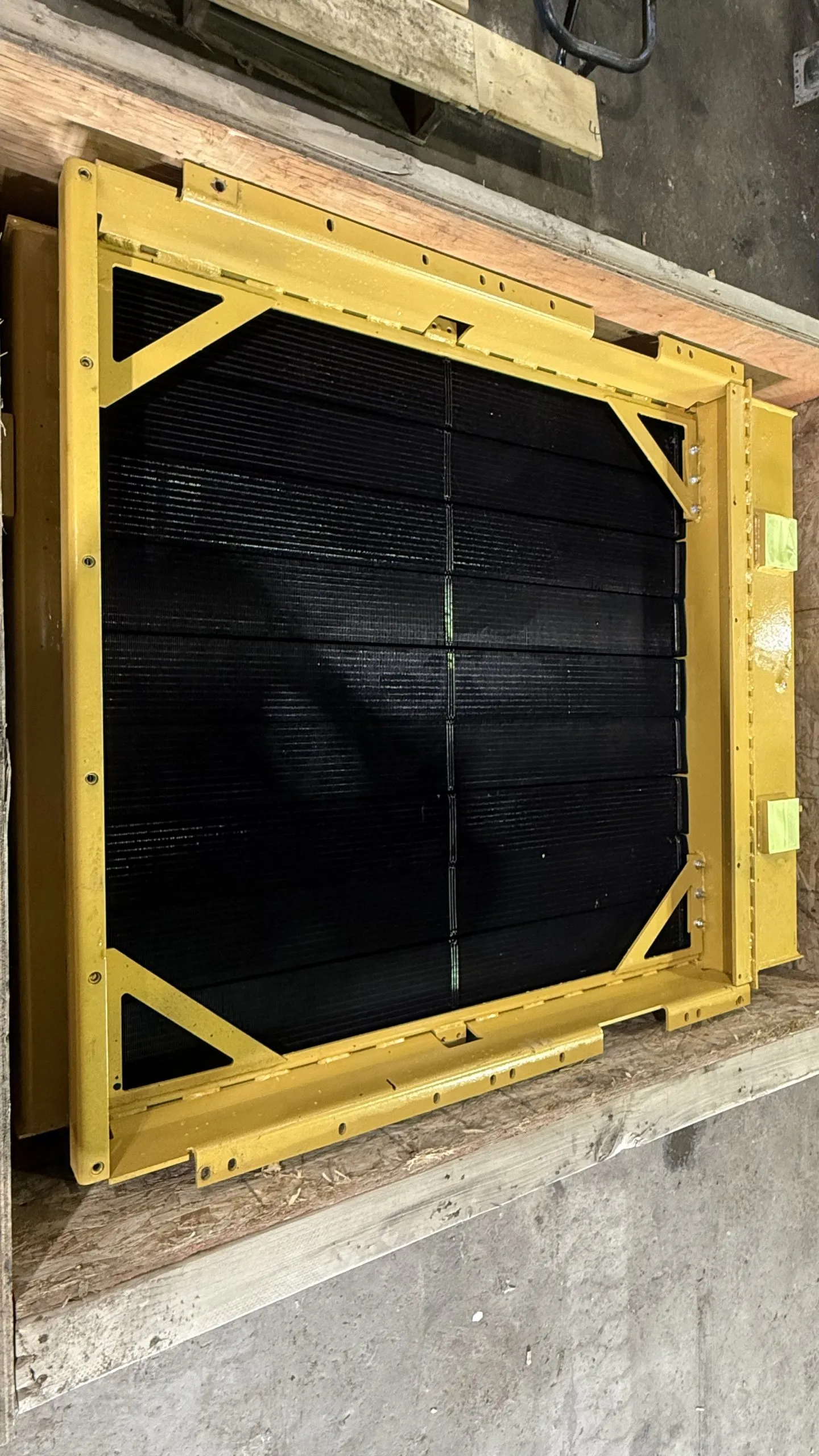 A large, framed black object sits on a wooden surface