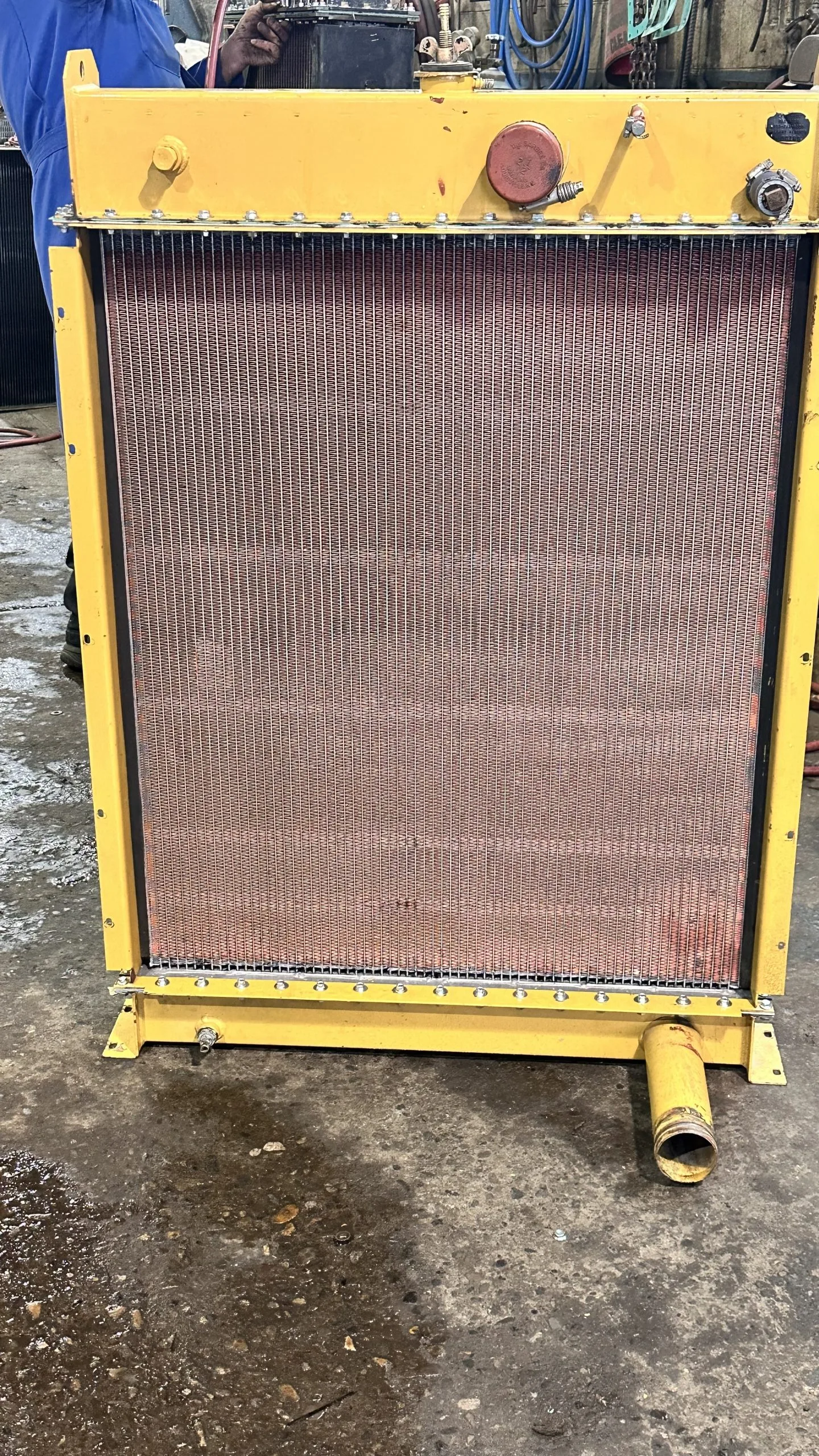 Radiator repair in northwest Calgary featuring a large yellow radiator with a mesh front and pipe